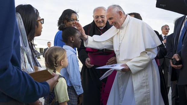 Pope Francis reaches out to 5th grader Omodelei Ojo of the Brooklyn borough of New York as he is greeted by children upon arrival at John F. Kennedy International Airport Thursday, Sept. 24, 2015, in New York. The pope is on a five-day trip to the USA, which includes stops in Washington DC, New York and Philadelphia, after a three-day stay in Cuba. REUTERS/Craig Ruttle/AP/POOL