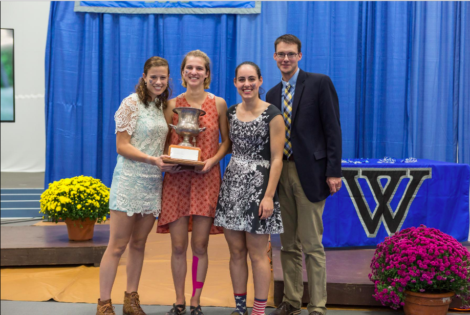 Seniors Sara Vannah, Sonja Cwik and Edie Sharon celebrate their Seven Sisters Championship with Coach Phil Jennings at the luncheon following the race. Photo courtesy of Wellesley Blue