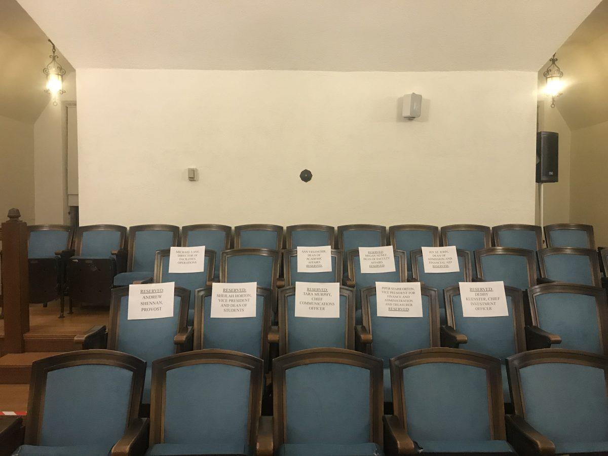 Image of empty seats at town hall, reserved for senior administration.