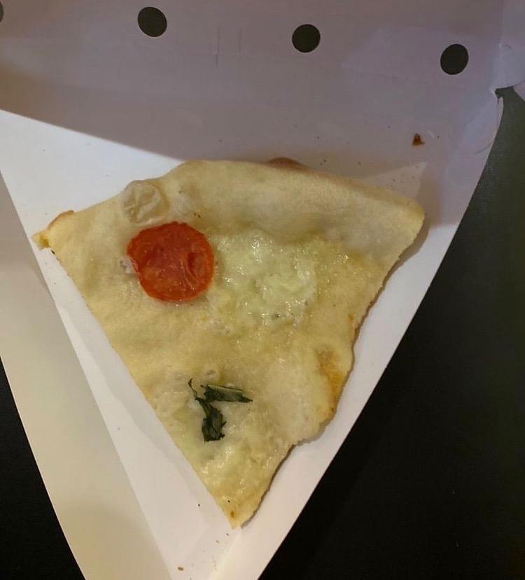 A piece of pizza missing topings.