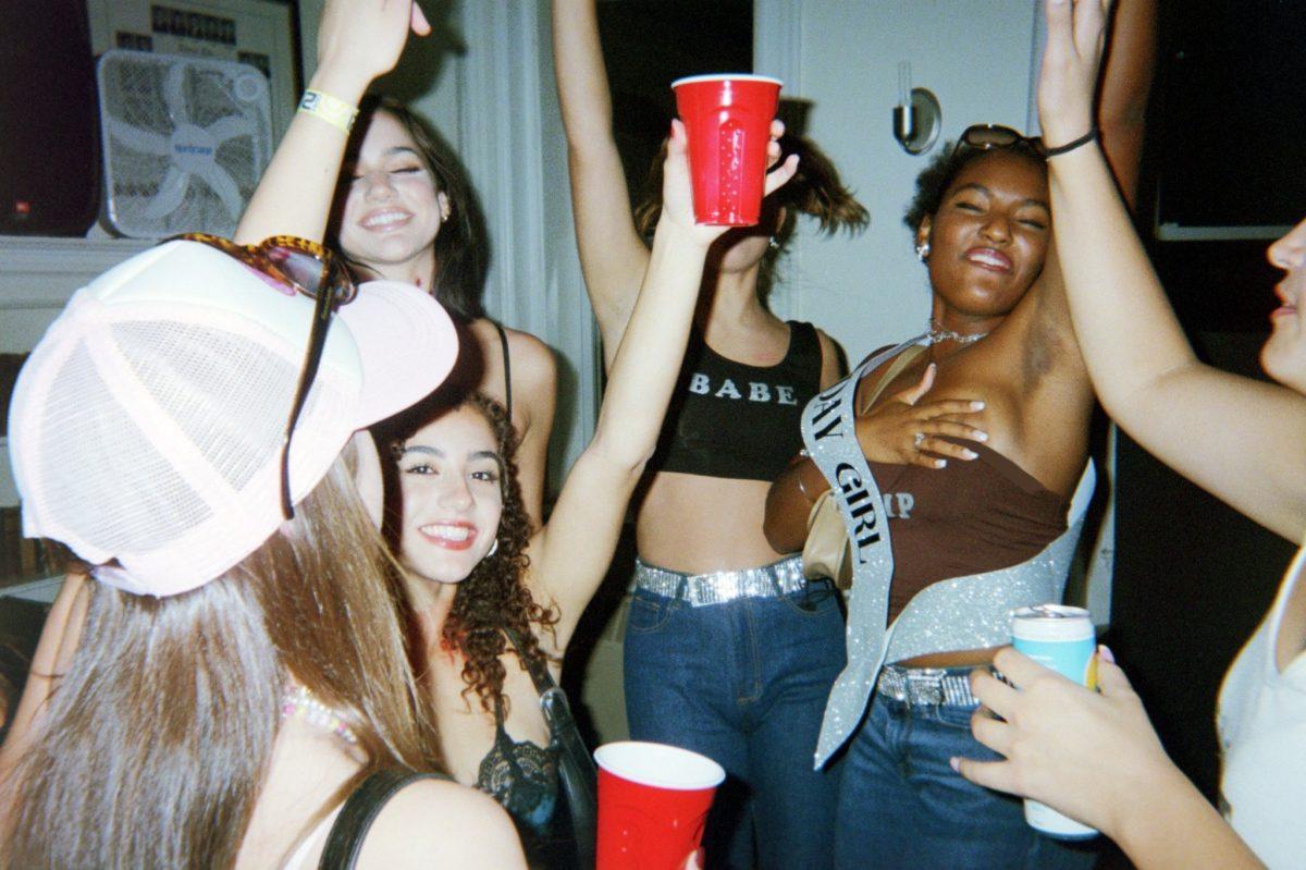 A group of college aged women at a party holding red solo cups