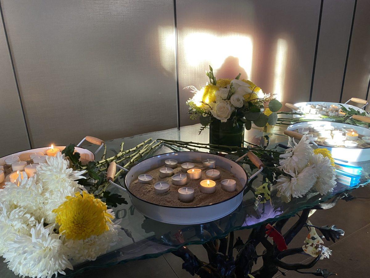 small lit candles and flowers laid out on table