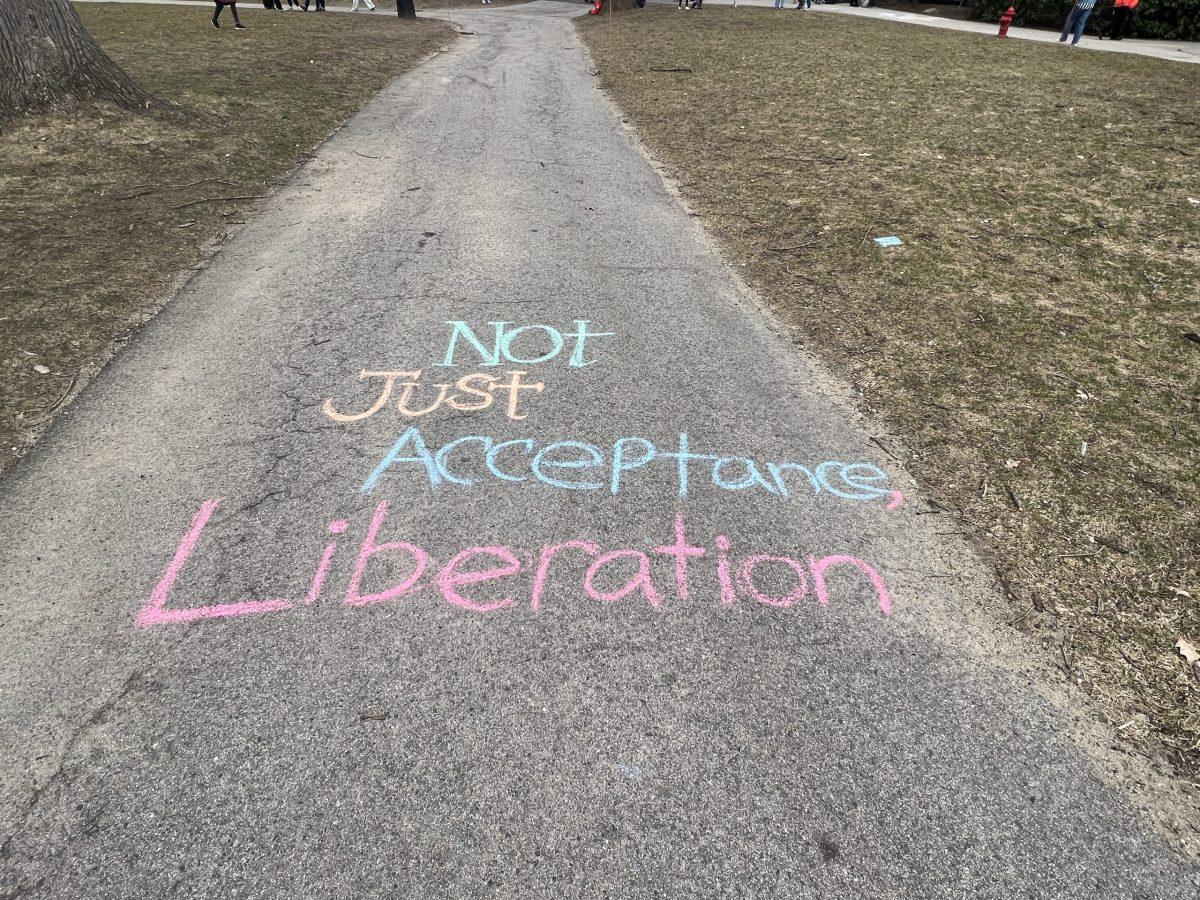 Chalk art on Wellesley's Academic Quad Reading "Not Just Acceptance, Liberation"