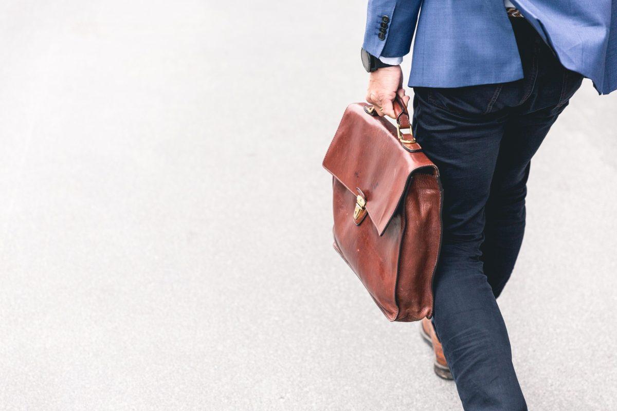 Person carrying a briefcase. Only their lower body is visible