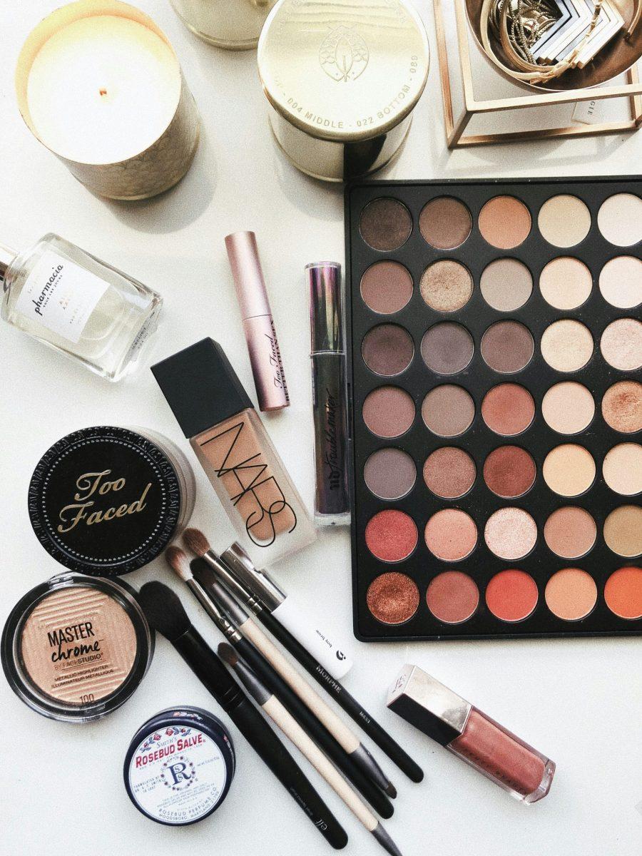 A variety of makeup products spread out on a white table